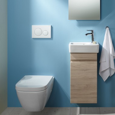Un WC suspendu Renova Plan et un lavabo sont fixés sur un mur bleu clair