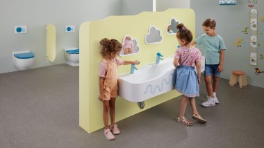 Les enfants jouent dans des locaux sanitaires équipés de Geberit Bambini