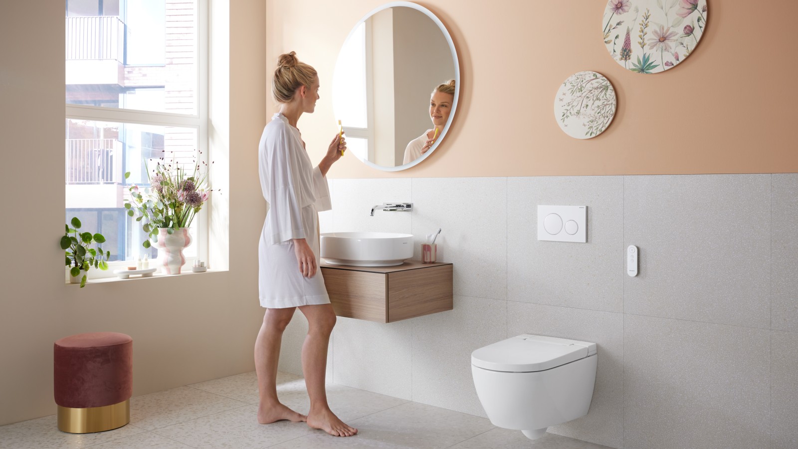 Une femme dans une salle de bains avec Geberit AquaClean Alba, un WC économique avec fonction douchette Une femme dans une salle de bains avec Geberit AquaClean Alba, un WC économique avec fonction douchette