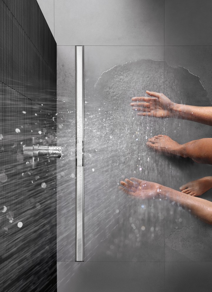 Personne se douchant dans une douche de plain-pied équipée du caniveau de douche Geberit CleanLine
