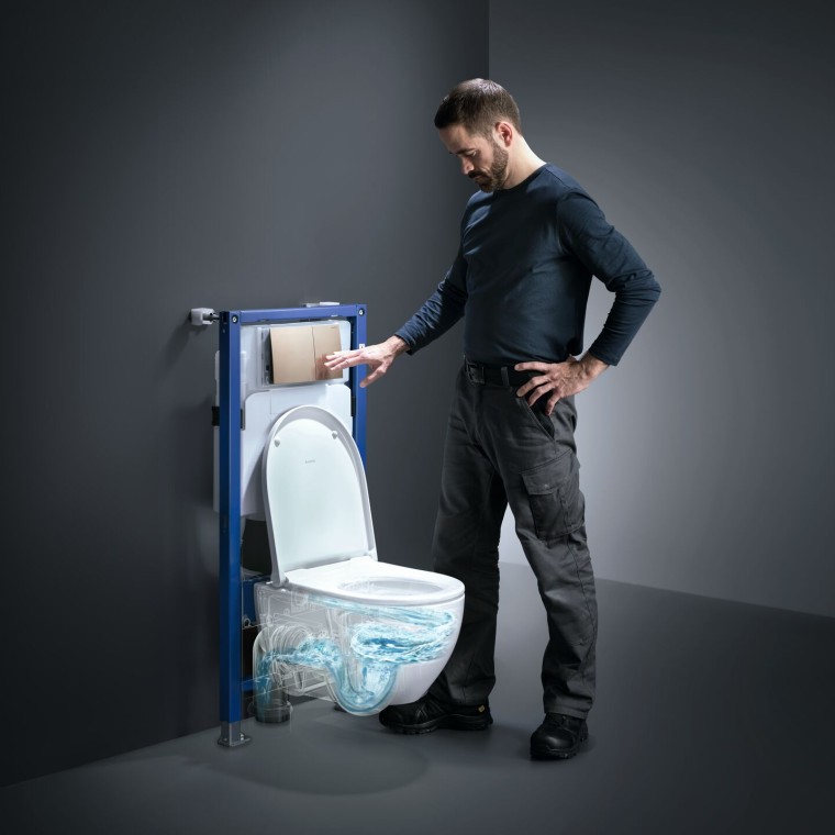 Un homme actionne la technologie de rinçage TurboFlush d'un WC Geberit Acanto