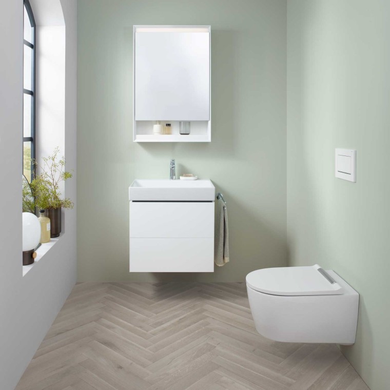 Zone lavabo Geberit ONE avec petit lavabo, meuble sous lavabo et armoire de toilette, ainsi qu'un WC lavant. Zone lavabo Geberit ONE avec petit lavabo, meuble sous lavabo et armoire de toilette, ainsi qu'un WC lavant.