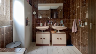 Salle de bains avec carrelage marron et deux lavabos