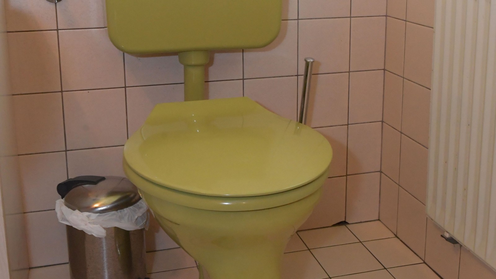 L'ancien WC avec réservoir de chasse apparent dans la salle de bains d'invités L'ancien WC avec réservoir de chasse apparent dans la salle de bains d'invités
