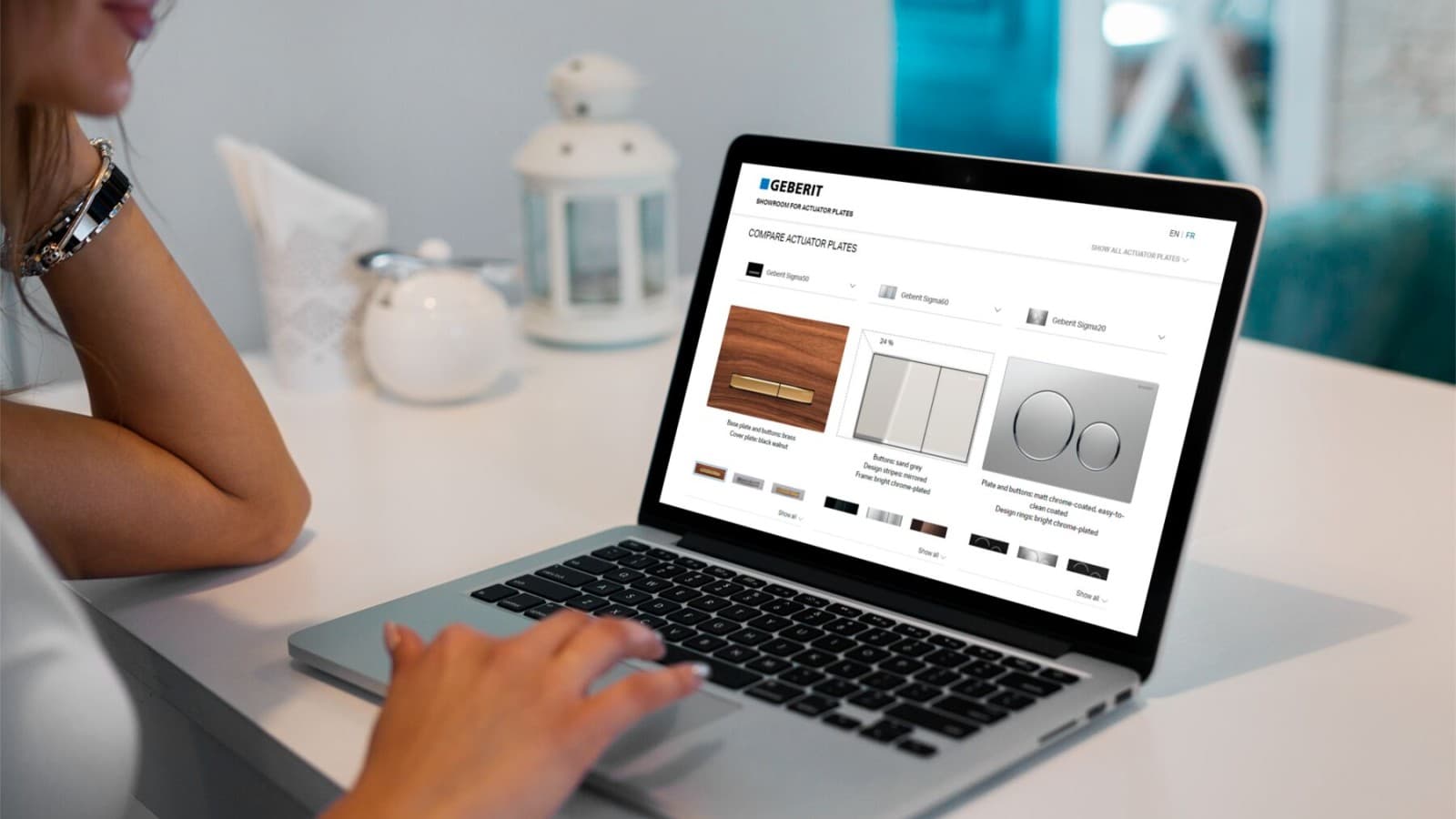 Frau ruft am Laptop den Betätigungsplatten-Showroom von Geberit auf Frau ruft am Laptop den Betätigungsplatten-Showroom von Geberit auf